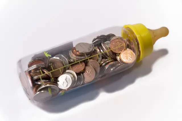 This baby bottle with money inside signifies the cost of having a baby and the cost of raising a baby adds up quickly! 