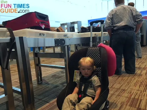 I rolled my toddler through the airport in his car seat using a car seat dolly that I made using a basic luggage cart.