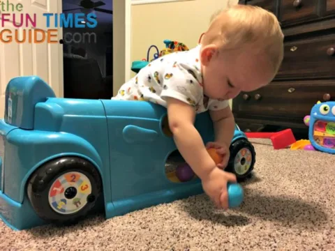 Playing with the colorful balls and the ball ramp on the Fisher Price Crawl Around Car door.